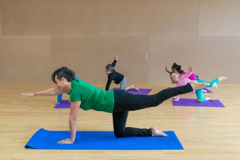 A woman teaching kids yoga.