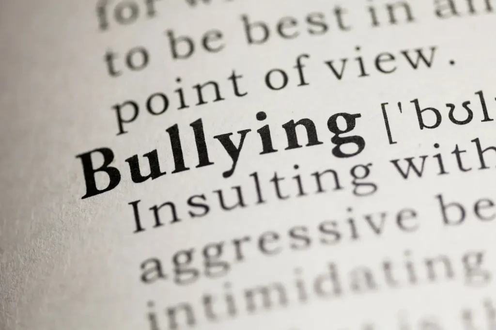 Dictionary definition of "bullying" showing the word in bold with its meaning: "Insulting with aggressive behavior or intimidating.