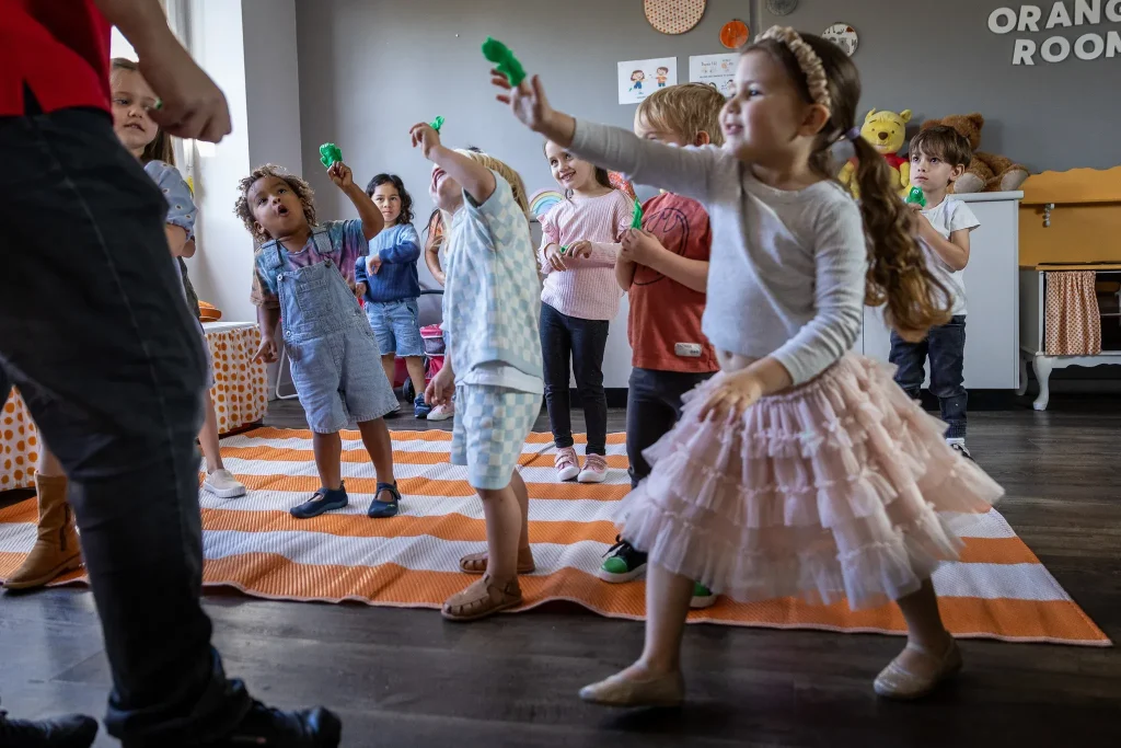 early years children moving to music with frog puppets on their fingers